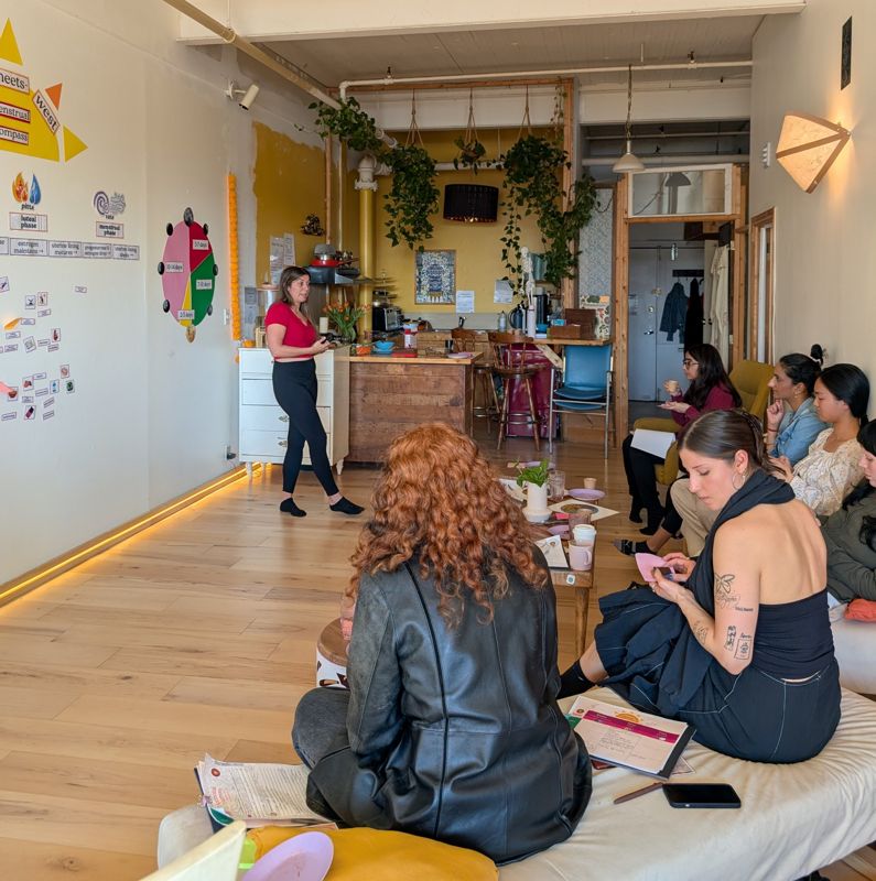 A facilitator leading a menstrual cycle workshop in a cozy studio